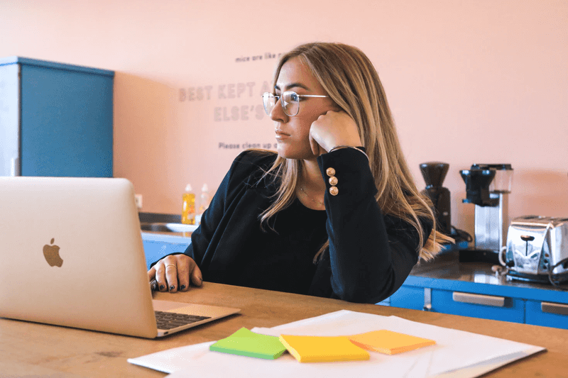 Woman thinking in front of a computer